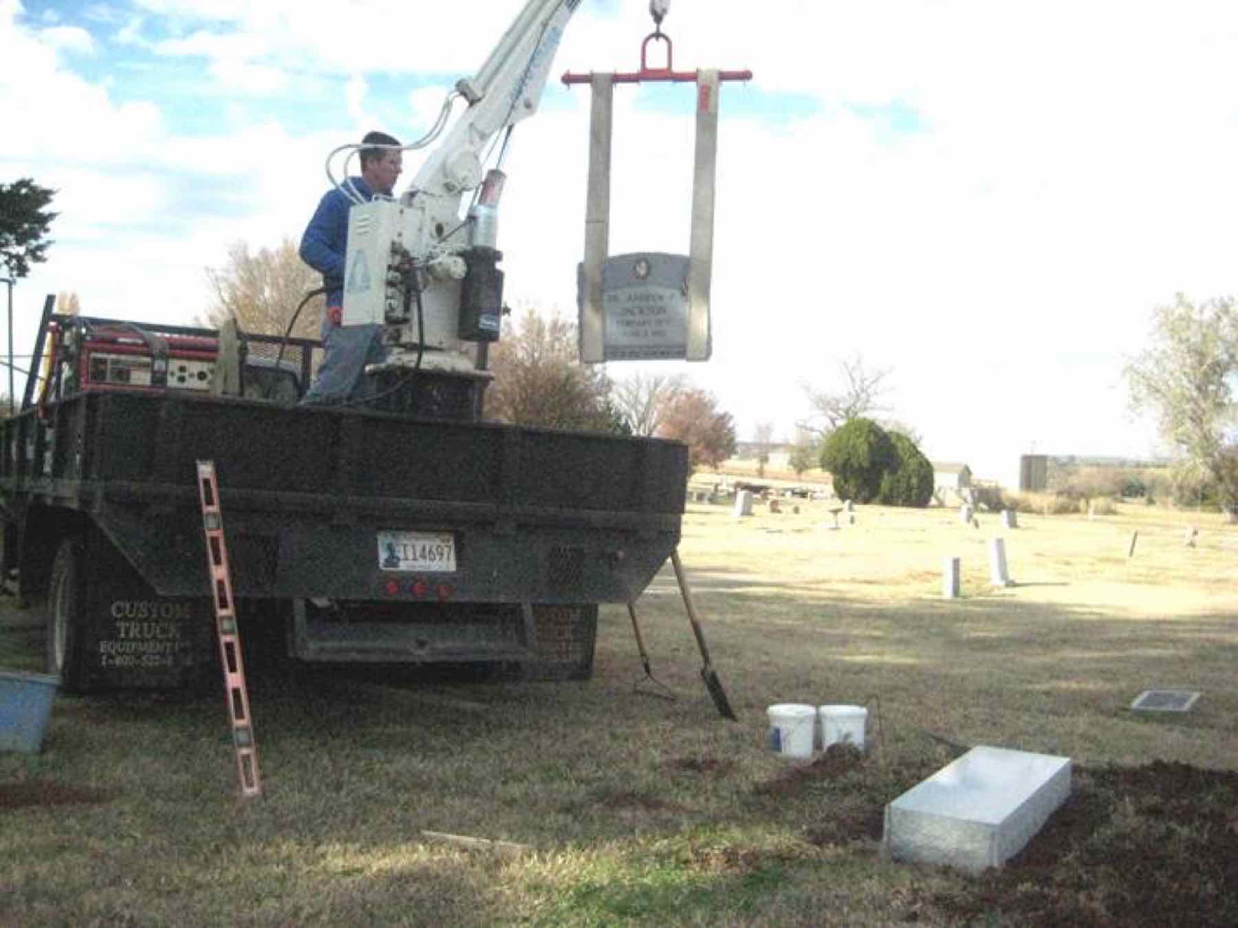 Installation at Summit View Cemetery, Guthrie, Oklahoma — the headstone lifted from the truck by crane over the prepared foundation