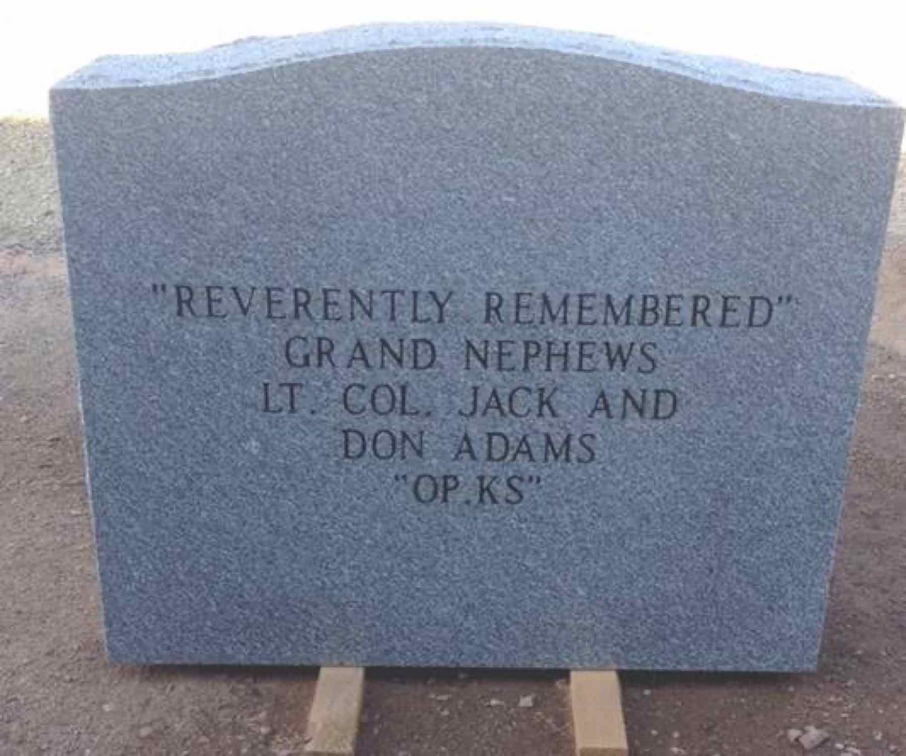 The headstone reverse: 'REVERENTLY REMEMBERED · GRAND NEPHEWS · LT. COL. JACK AND DON ADAMS · OP KS' — the dedication by Dr. Jackson's grand-nephews of Overland Park, Kansas