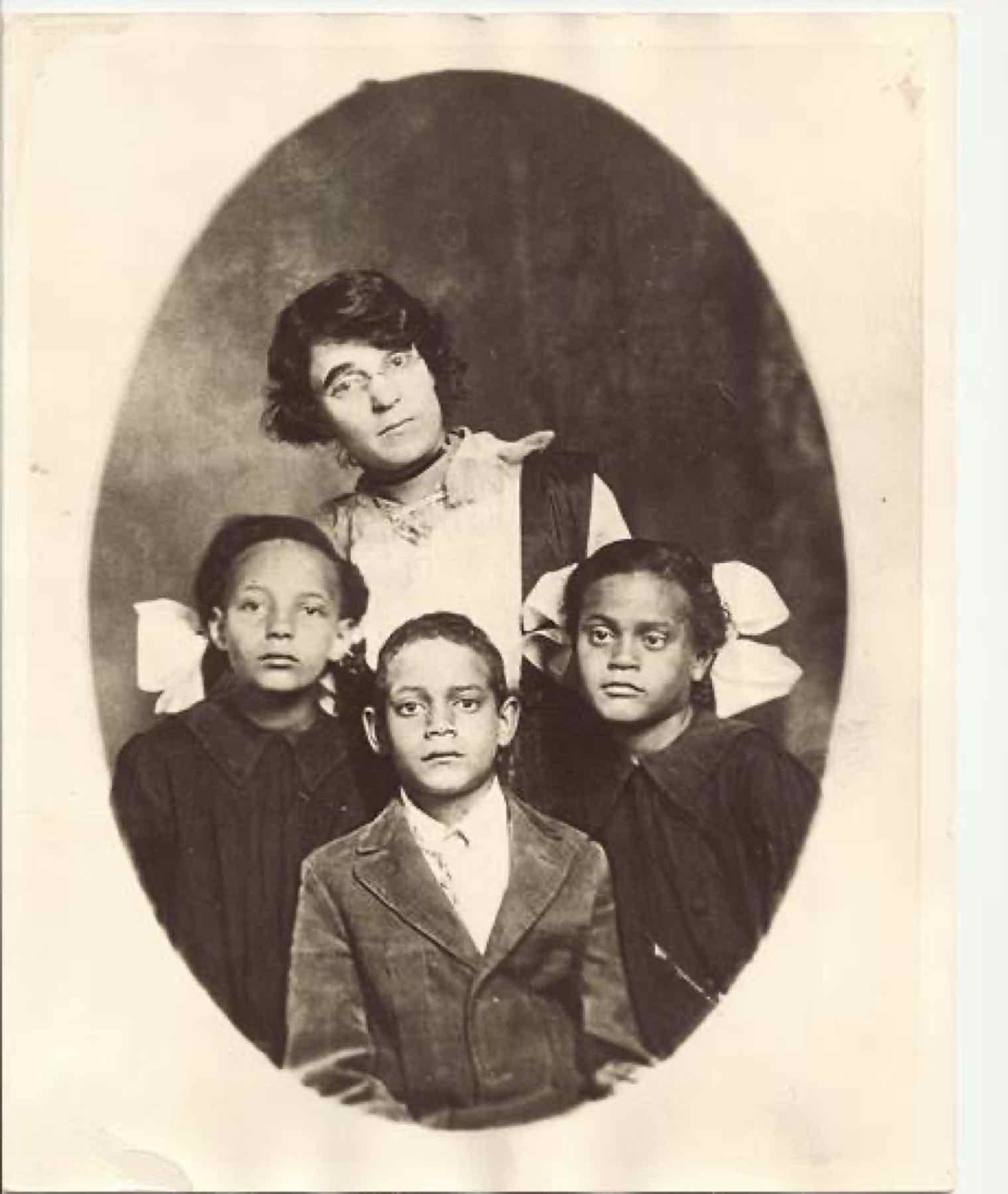 Oval studio portrait of a woman with three children — two girls in hair ribbons and a boy in a suit jacket. From the Jackson family collection; the sitters are not identified in the collection records.